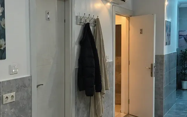 Oda girişinde askı ve temiz terlik — Güneşli, Masaj Salonun